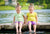 Twin girls on a lake shore, sprinkling water