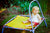 Little blonde girl sitting on a trampoline