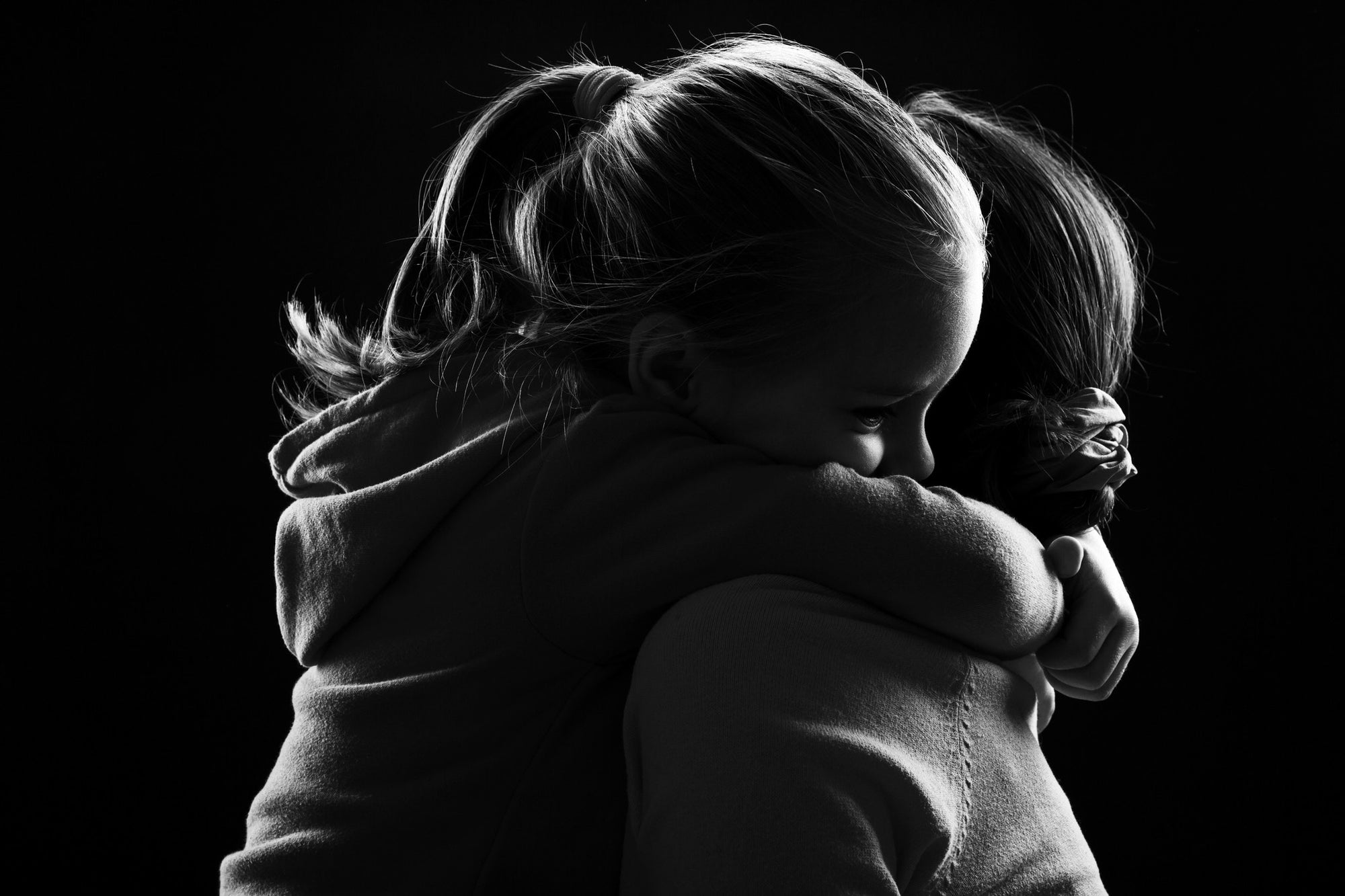 little daughter hugging mother holding tight
