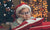 young boy with Santa Hat on resting his head on two pillows