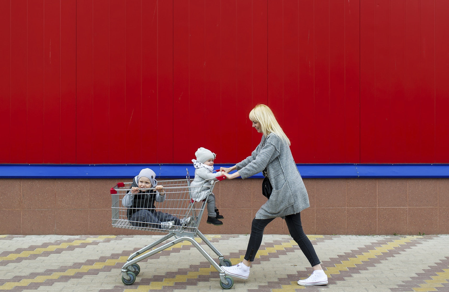 mother carring her children sitting in shopping trolley