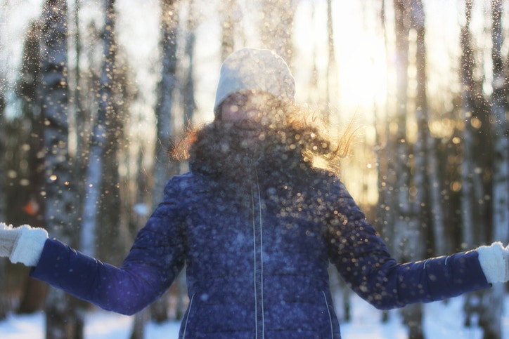 young woman enjoying winter in the woods