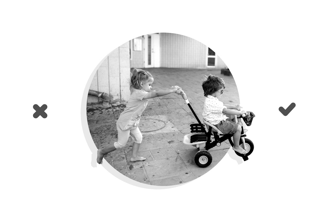 Girl pushing brother sitting on tricycle at yard