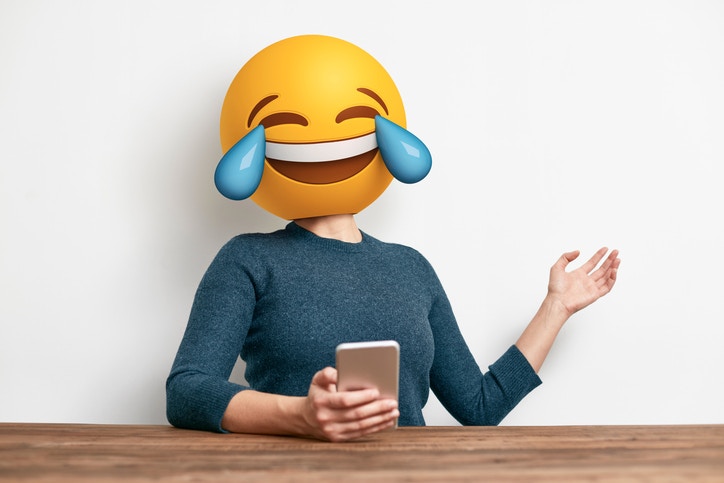 lady with smiling emoji holding phone