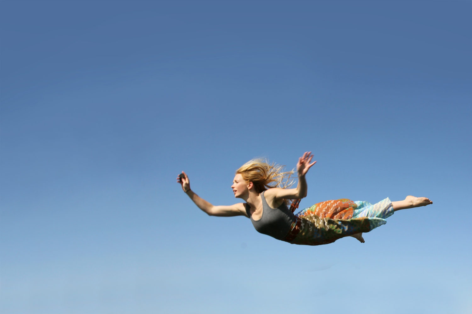 young woman with blonde hair flying or falling through the air