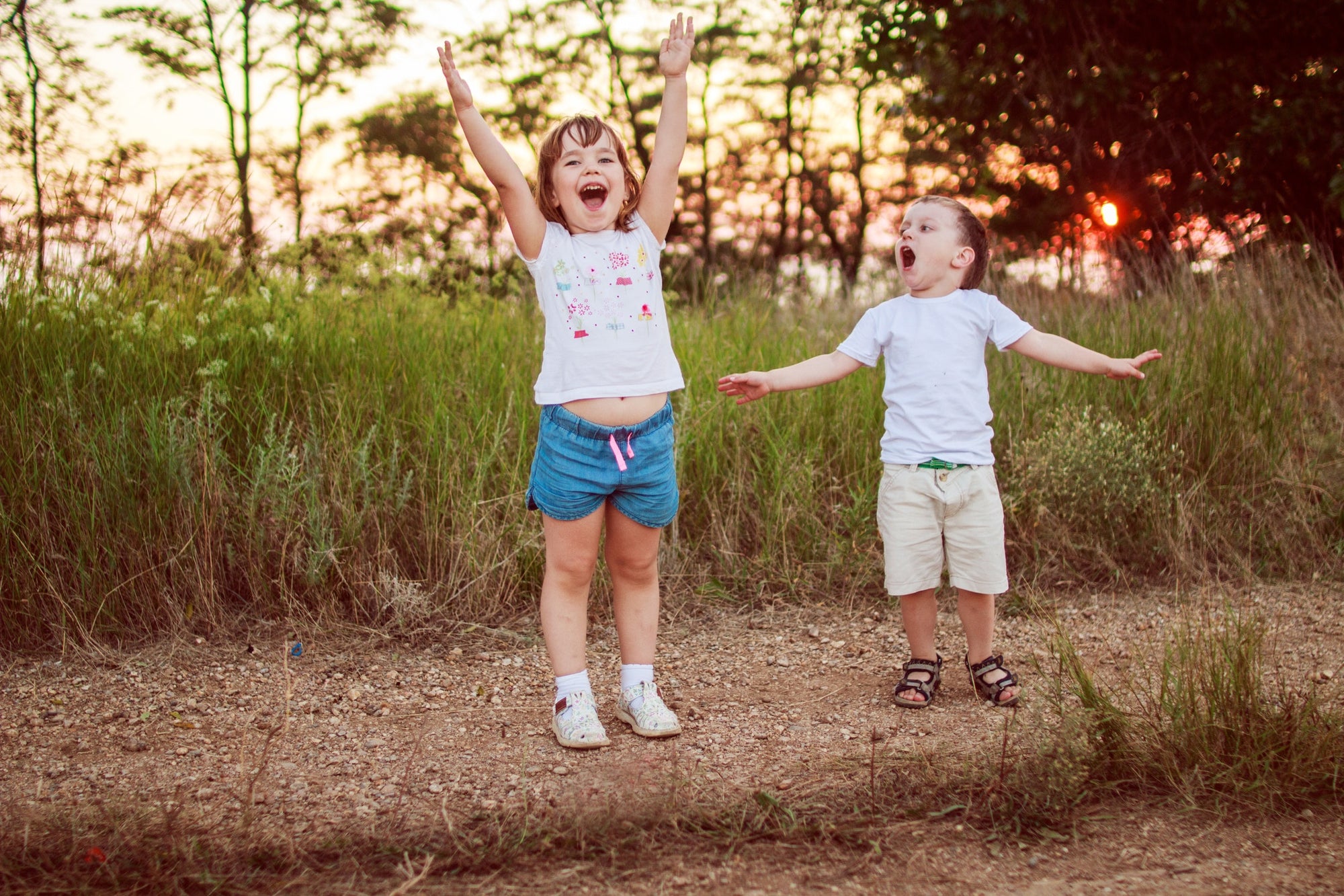 siblings putting their hands up in the air