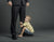little boy sits on the ground holding his father leg