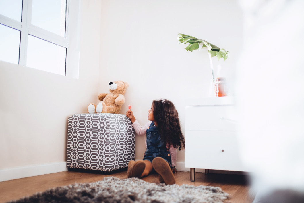 A girl playing in her room with teddy