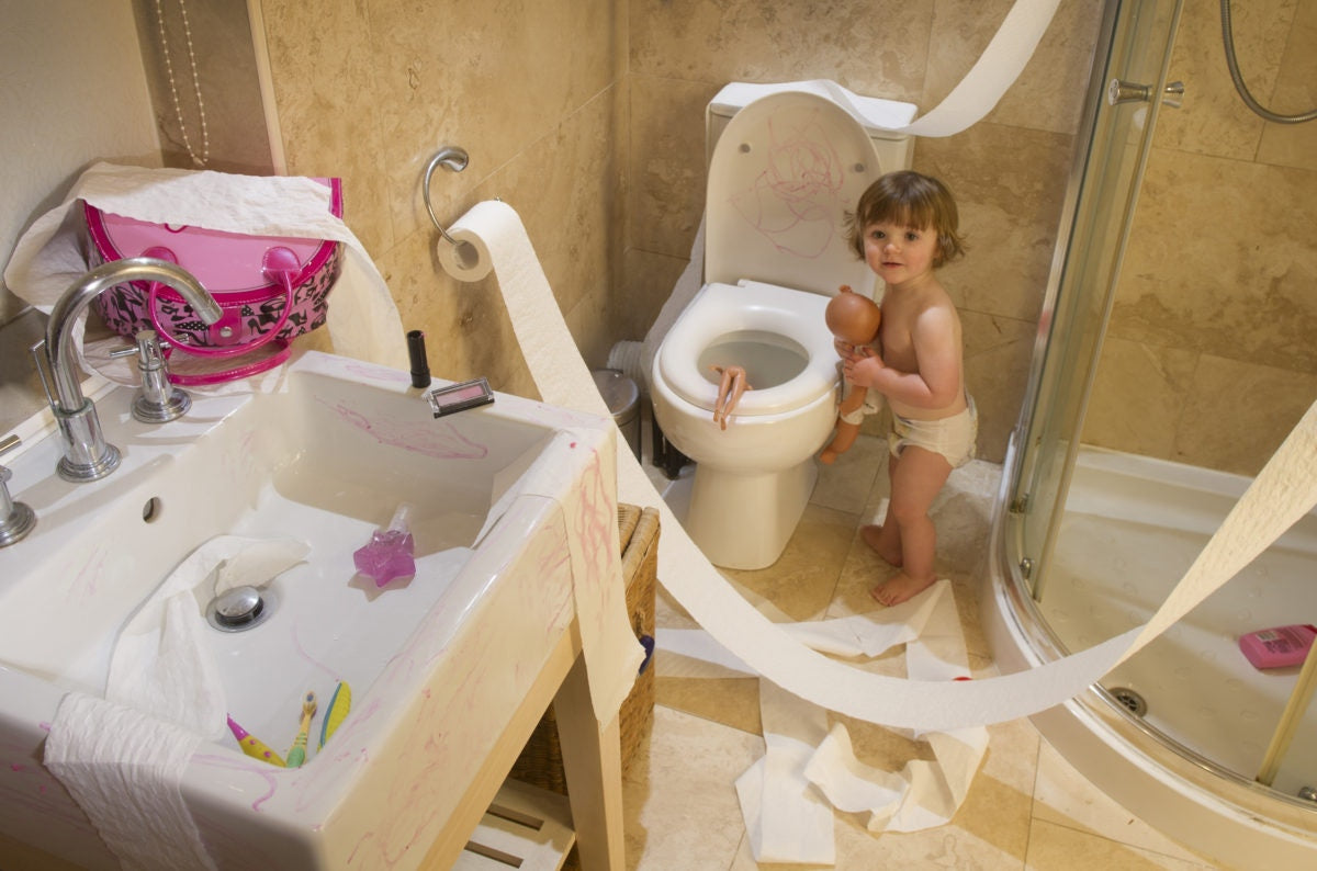 baby boy in a disorganised bathroom 