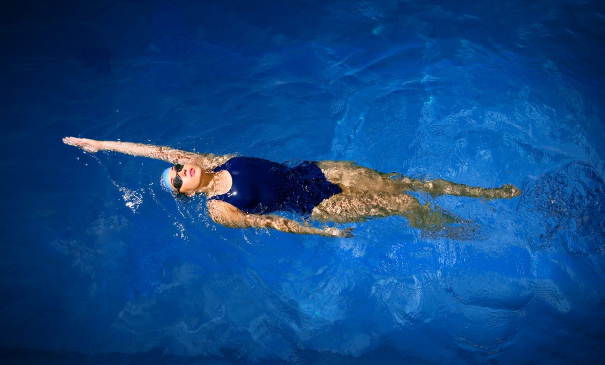 Top view of young women swimming in pool wearing goggles