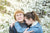 mother hugging her adult crying daughter on background of blooming trees