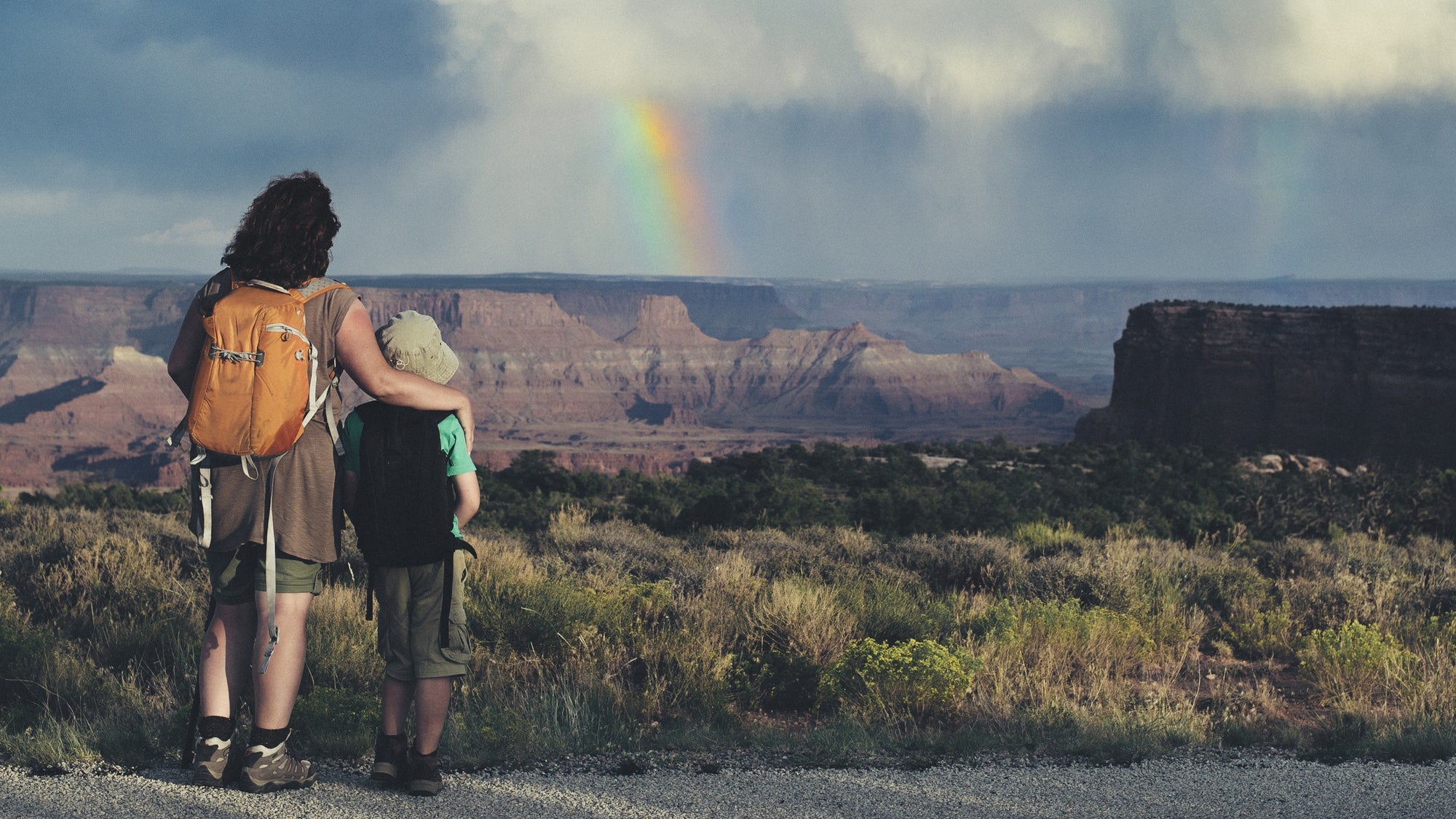 woman travelling with a child. Mother and son watching rainbow