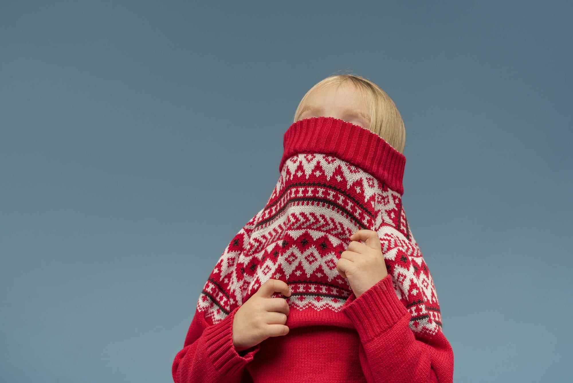 girl covers her face with red sweater