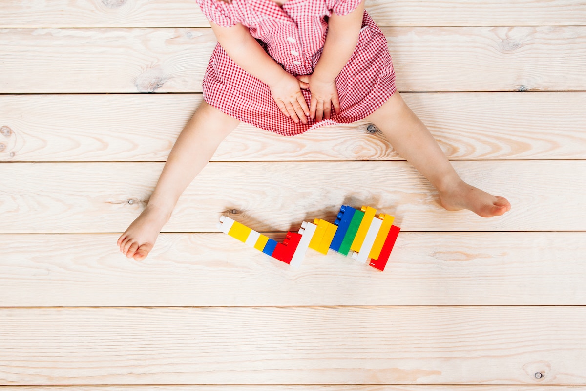 child with toy blocks on the floor
