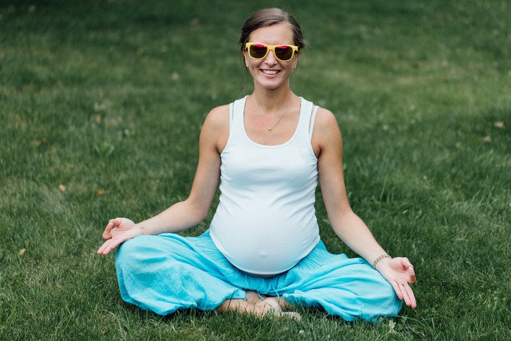 a happy pregnant lady doing yoga