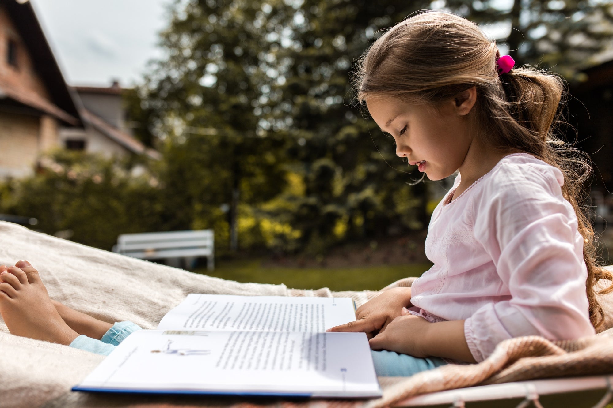 little girl studying outdoors on a sunny day