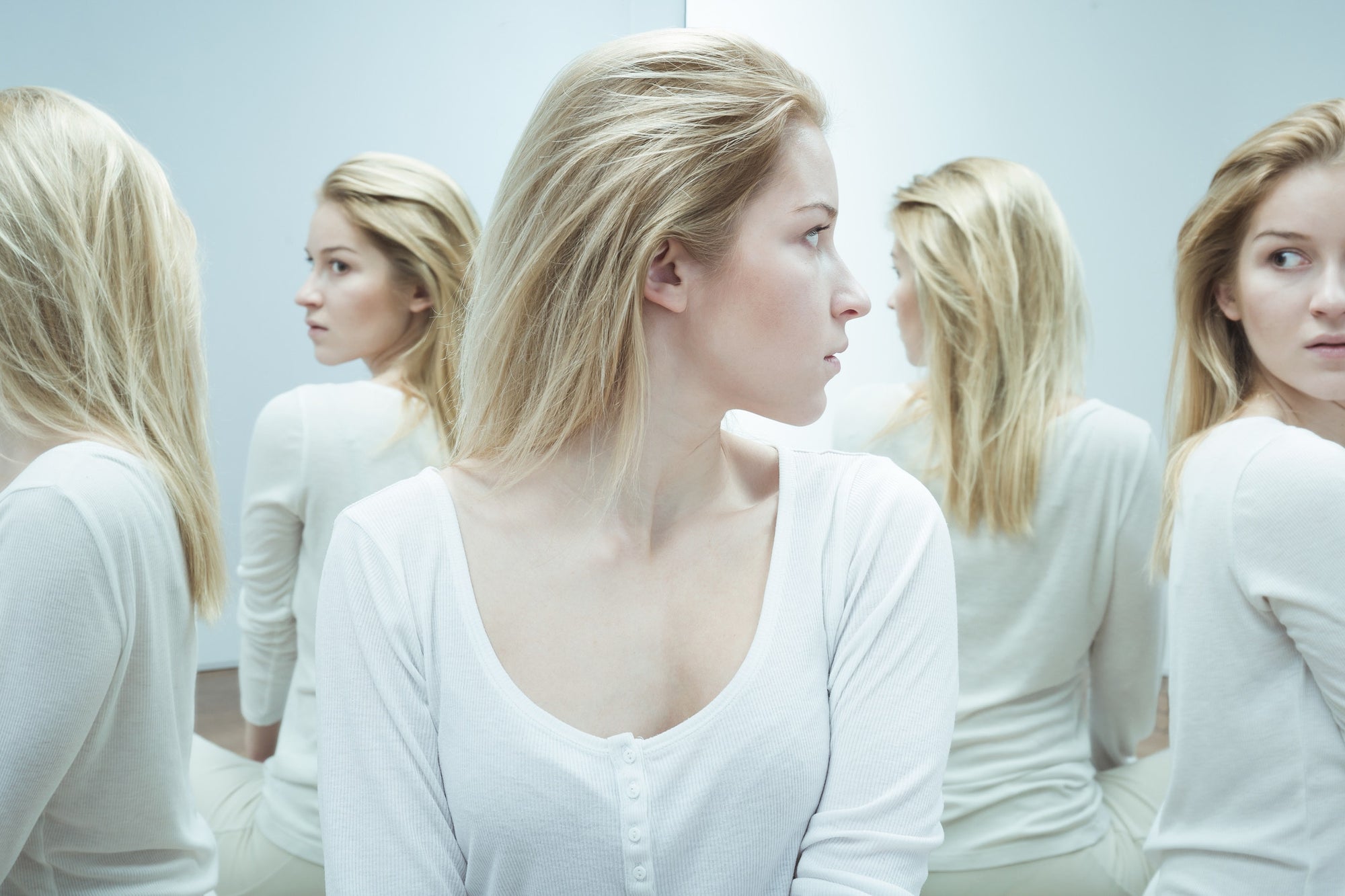 blond teenage girl staring at her reflection