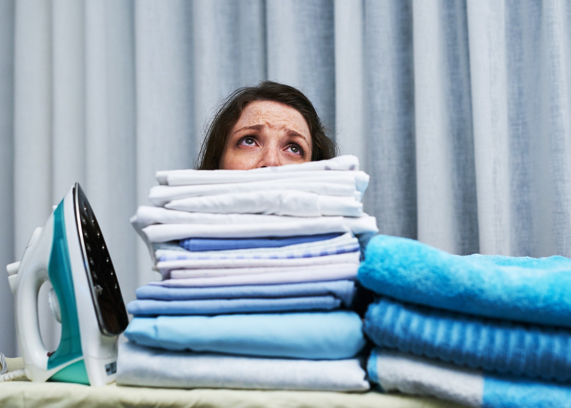 exhausted lady after ironing a pile of clothes