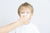 young boy blowing nose into tissue