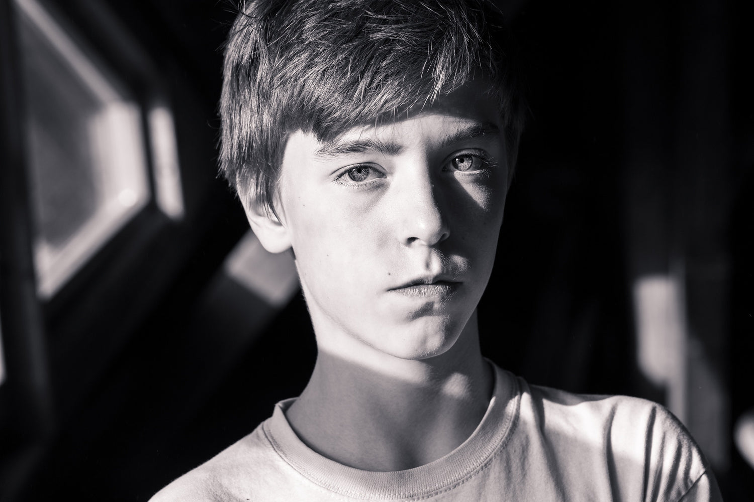 a boy looking at the camera  in the park in sun rays