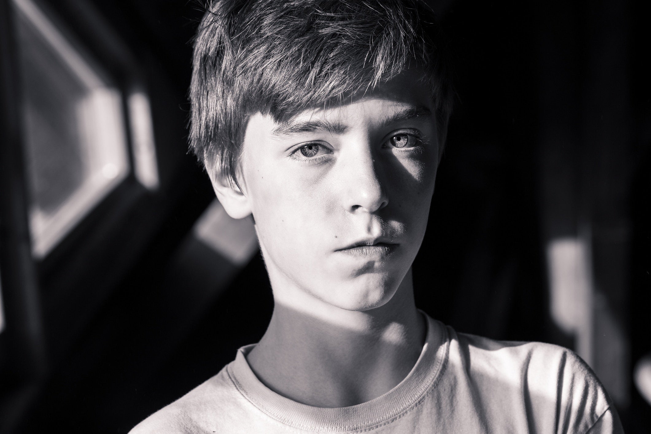 a boy looking at the camera  in the park in sun rays