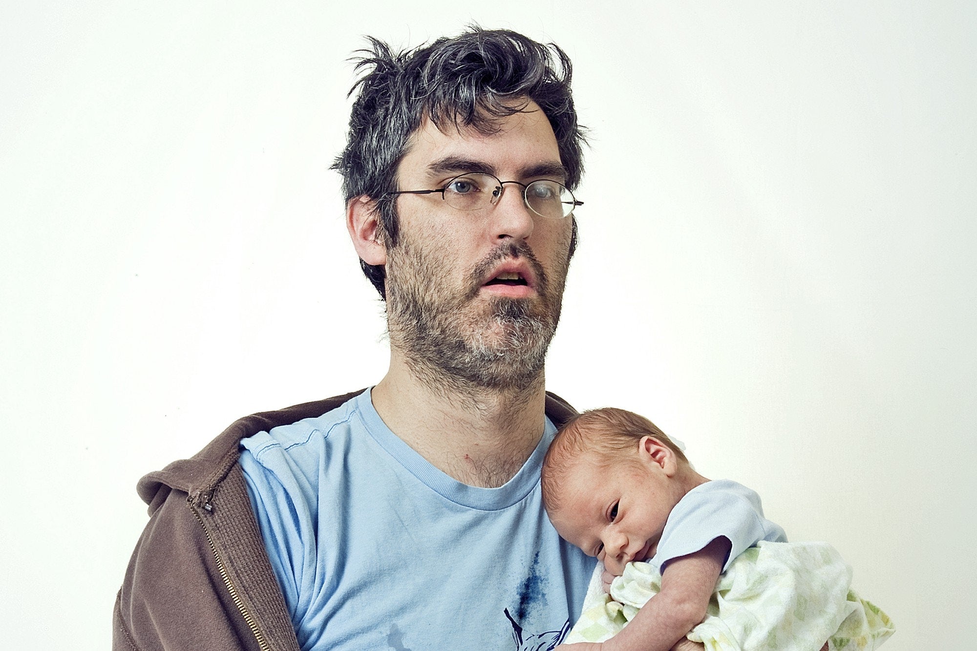 exhausted father holing new born baby