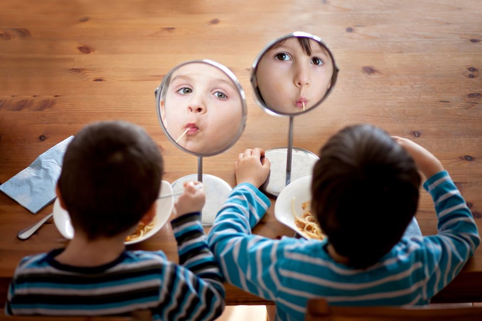 kids eating spaghetti looking at the mirror