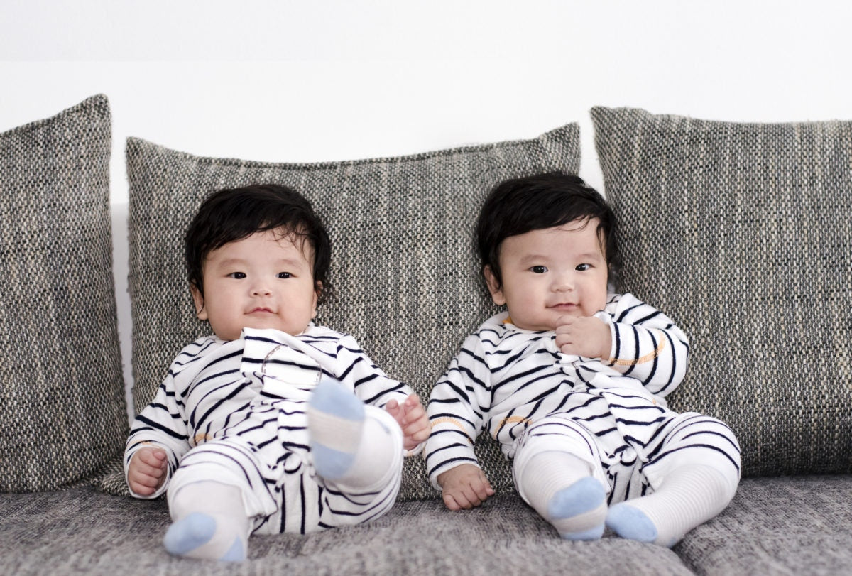 Young twins sitting on a couch