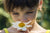 A little girl smelling flowers in a garden