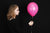 Young woman holding colorful pink balloon