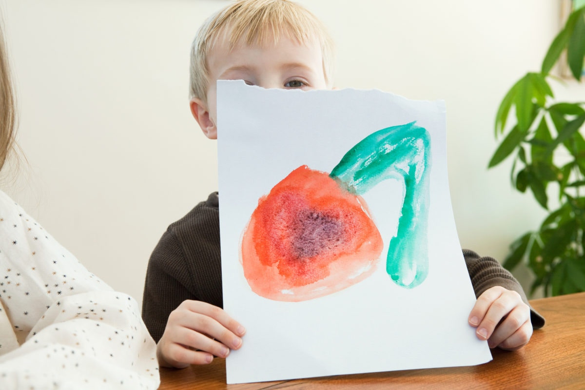 child showing his painting.