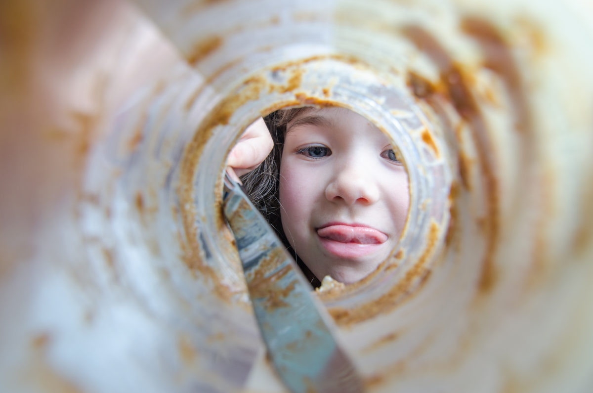 little girl looking into a empty food jar