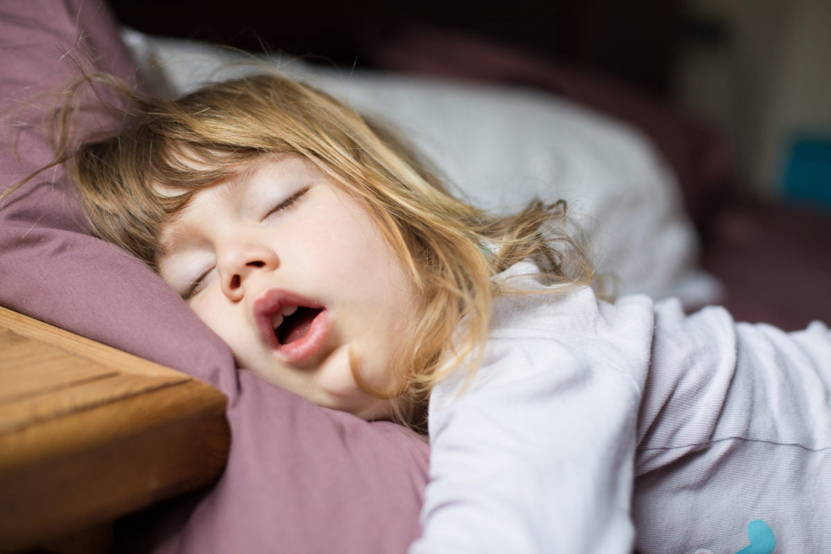 Little child girl sleeping with her mouth open in the bed