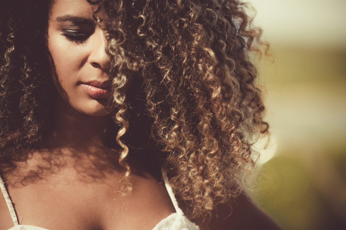 woman portrait with  curly hair in the sunlight