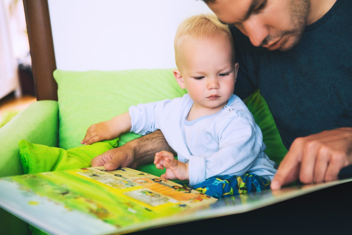 A father showing image in a drawing book to his baby