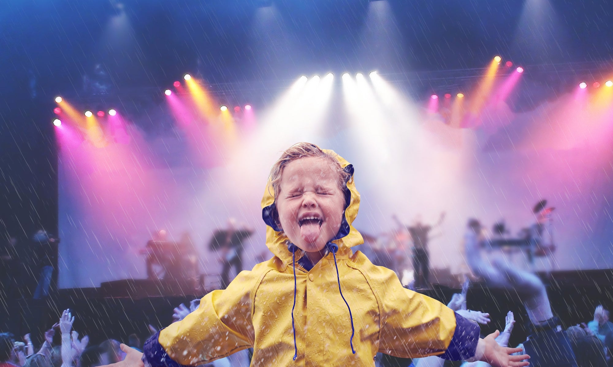 Cheerful boy wearing raincoat enjoying in rain  at music concert