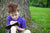 little boy sitting under the tree and writing in a book