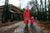 Mother with daughter wearing rain coat and rubber boots walking in a rainy weather 