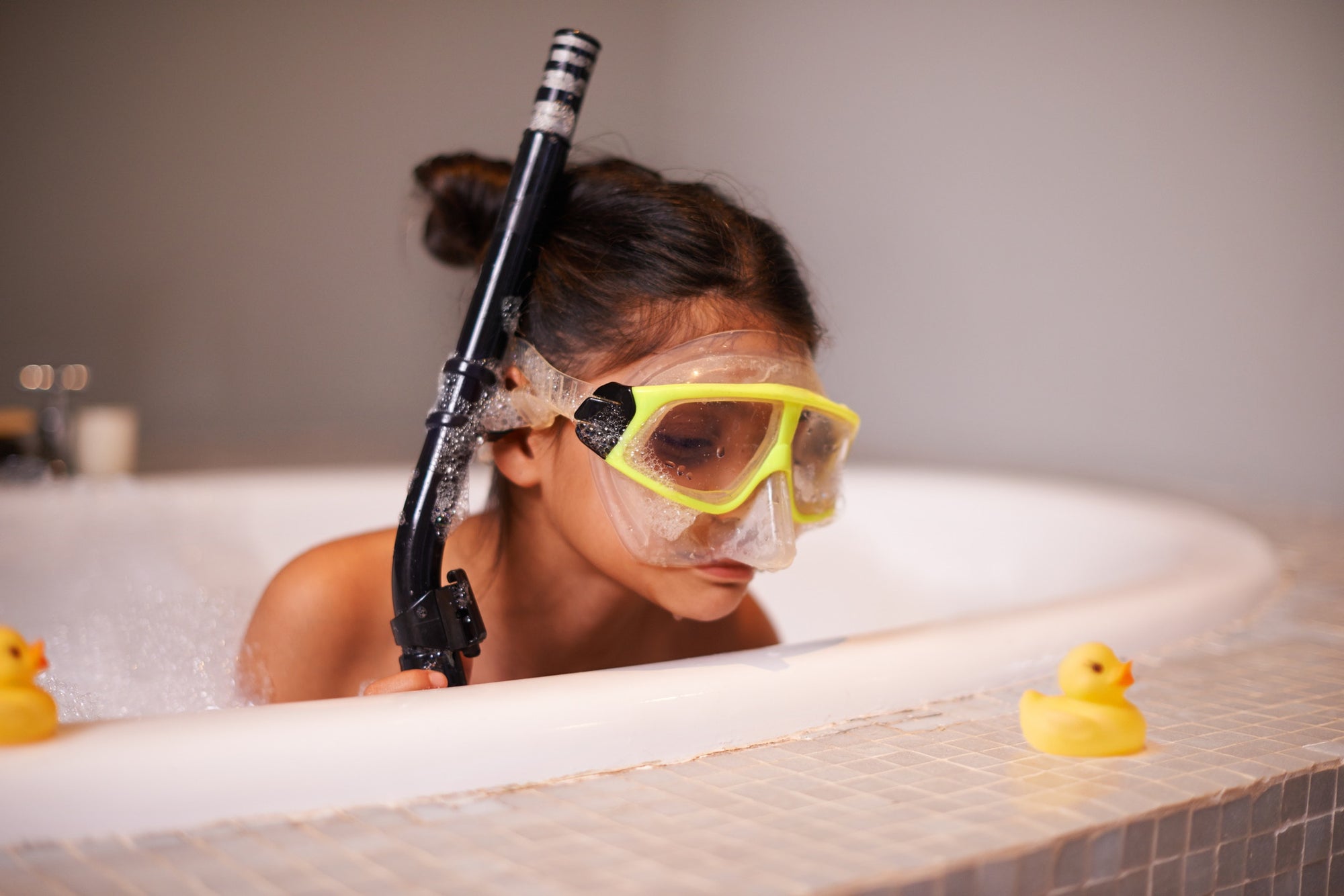 kid on a tub with breathing tube and swim googles
