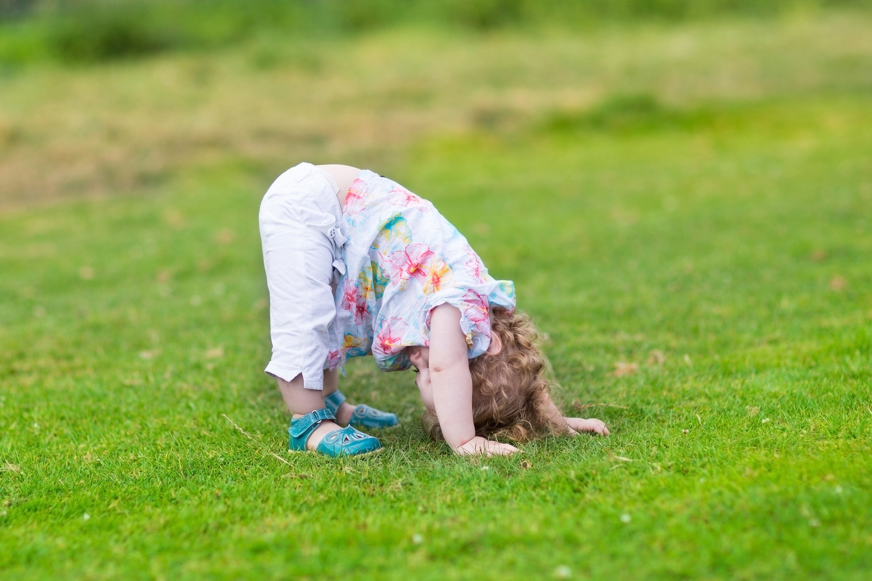 A kid is playing outside with head down