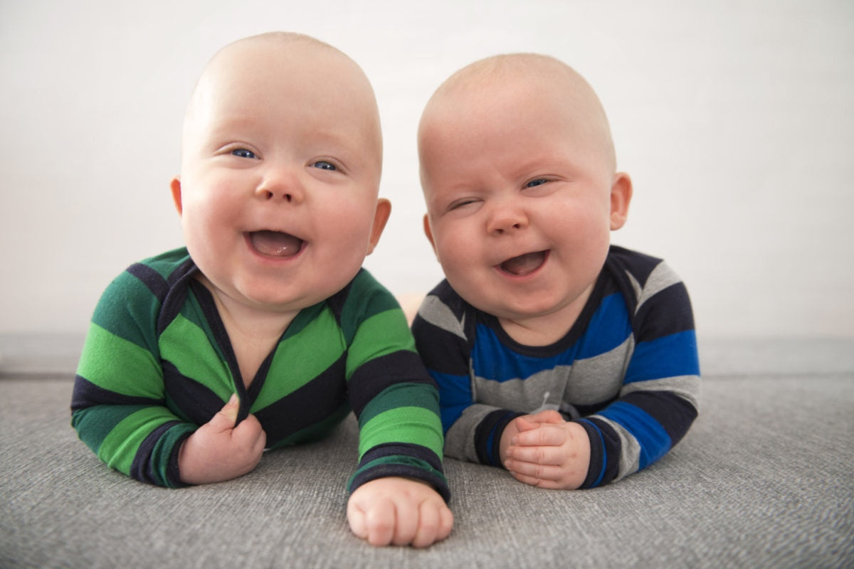 Twin babies laughing each other