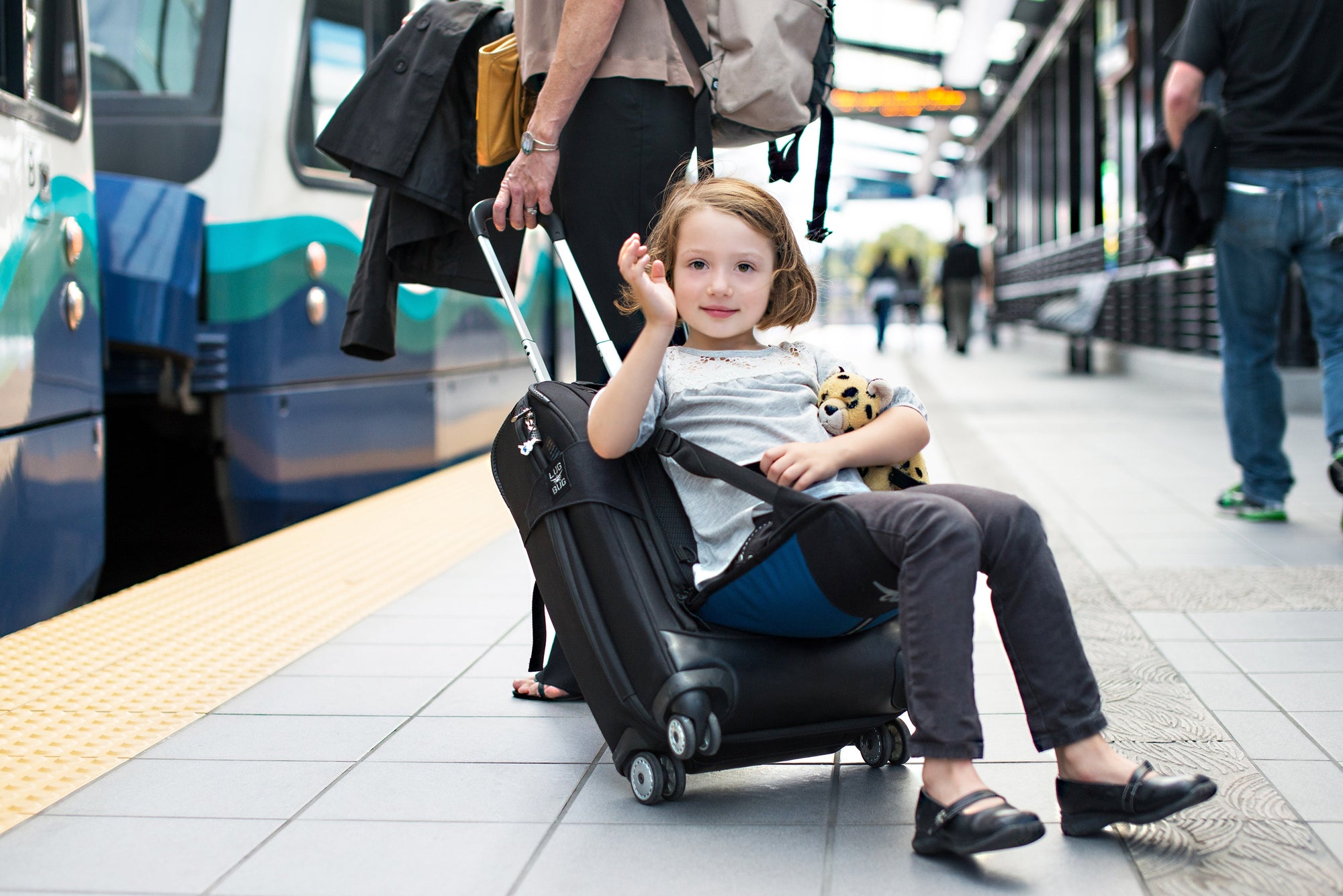 little girl sitting on suitcase seat