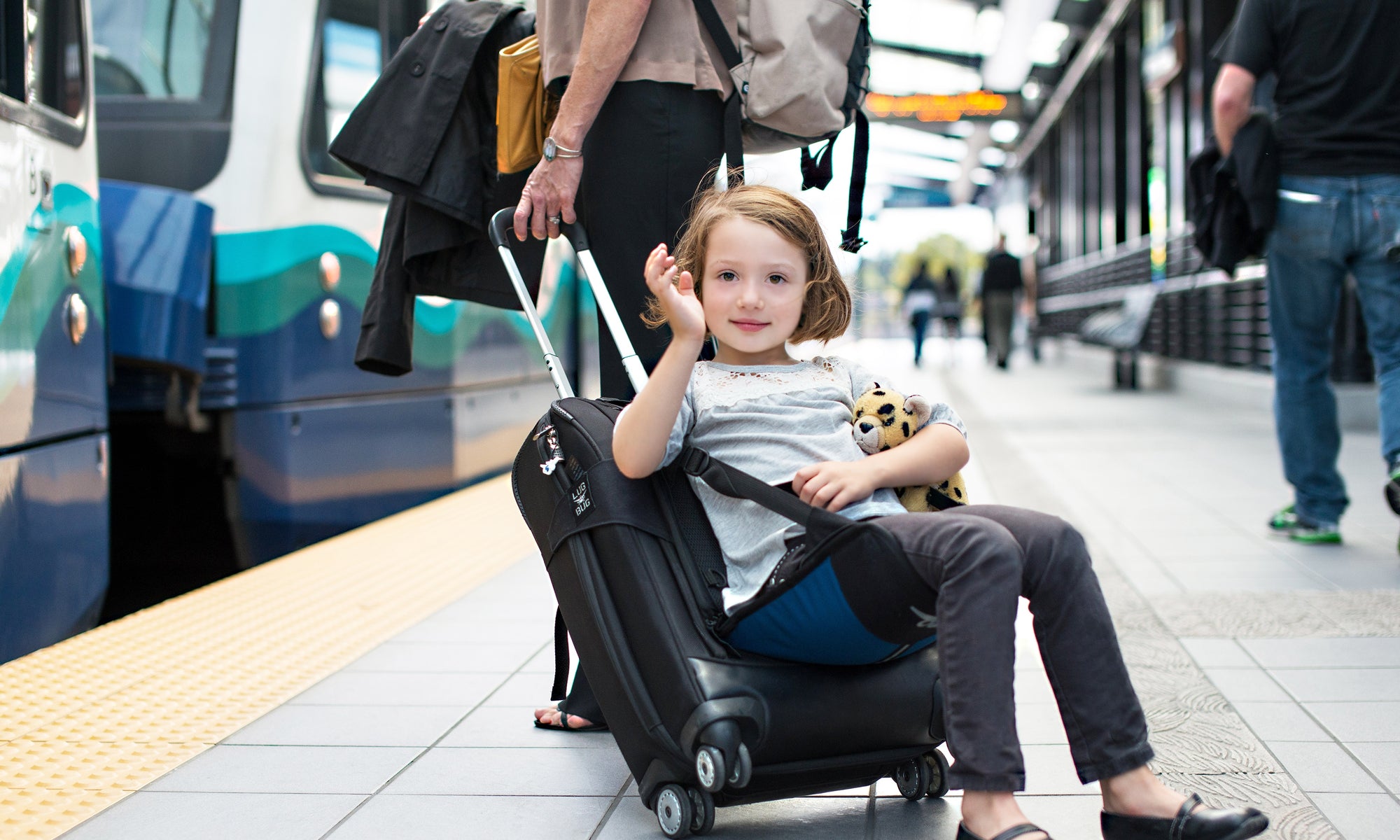 little girl sitting on suitcase seat