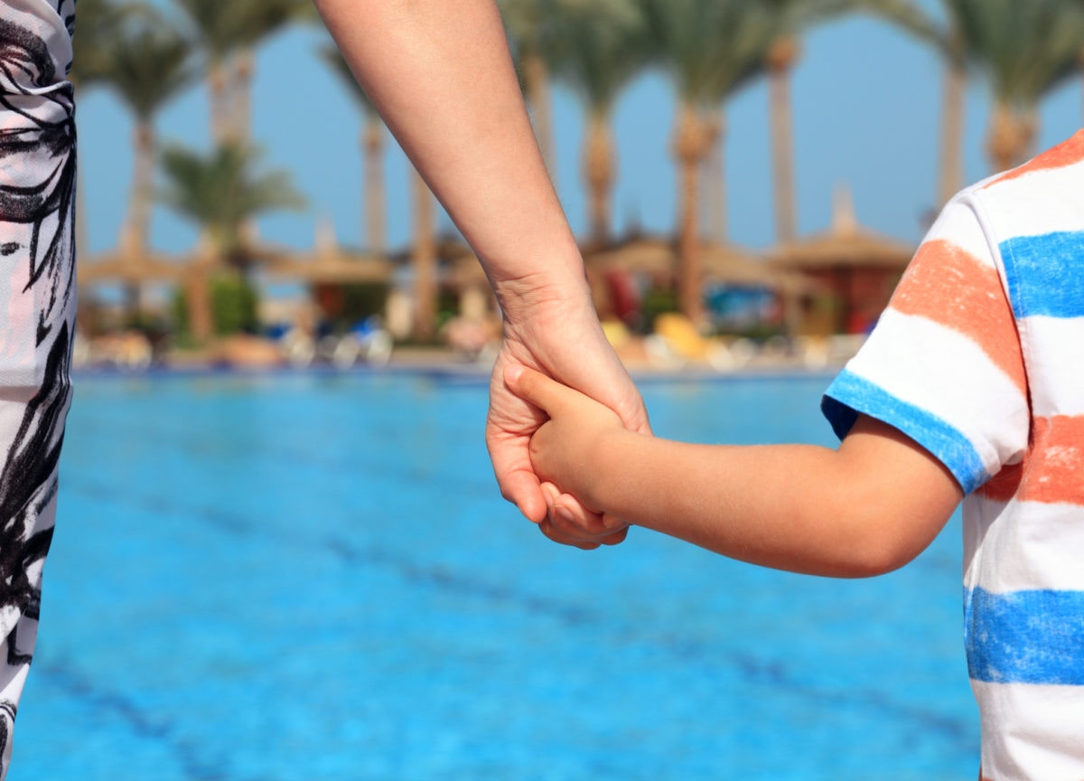 mother holding her child's hand at swimming pool