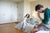 mother holding baby with stressed father in room