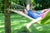 girl lying on colorful hammock at the garden reading book