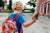 Mother holding hand of little daughter with backpack going to school