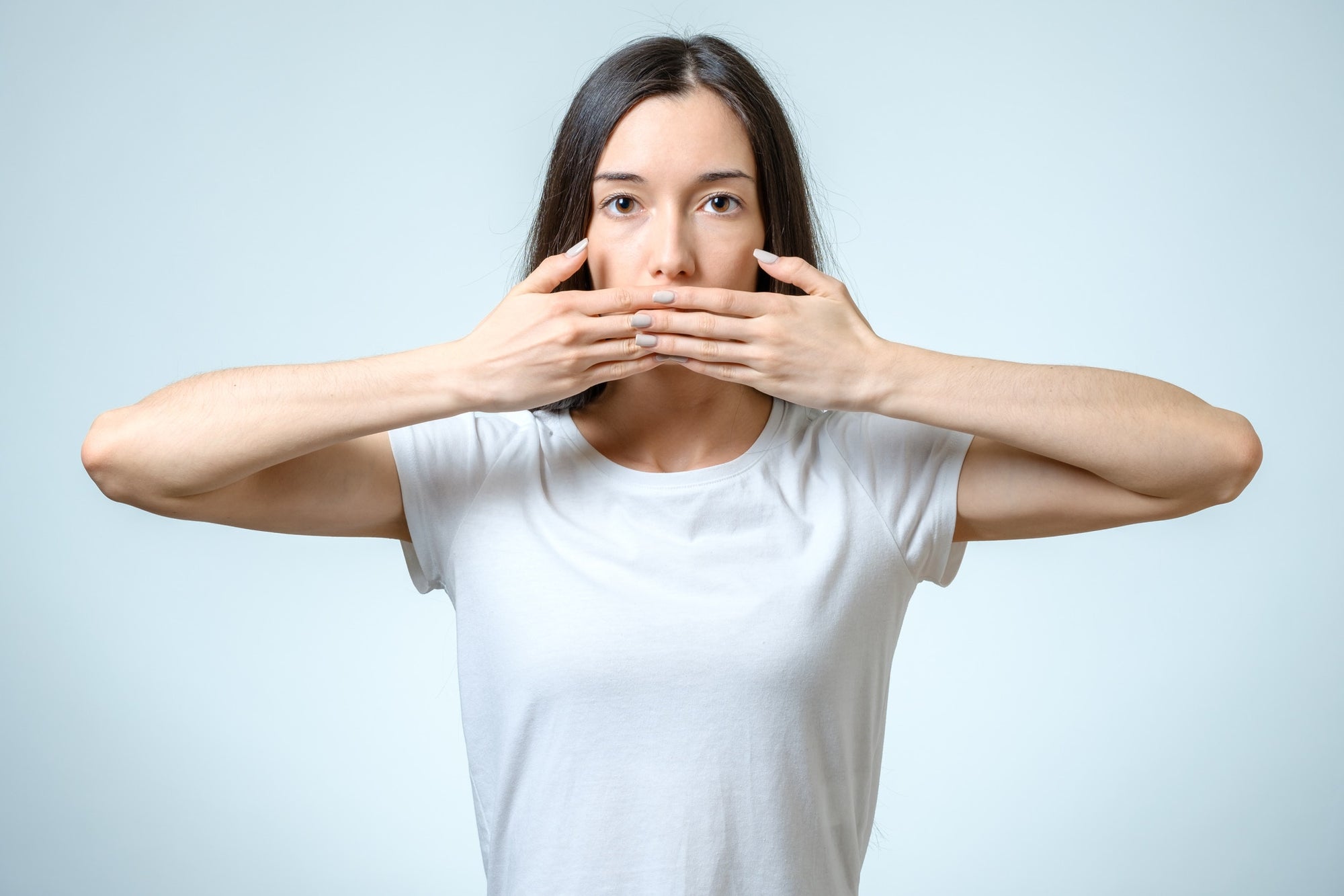 young woman covering her mouth with her hands