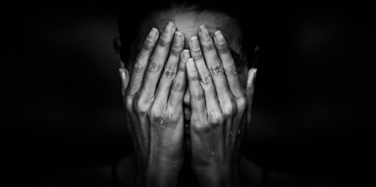 hands covering face crying woman