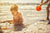 Mother splashin water on child in a beach